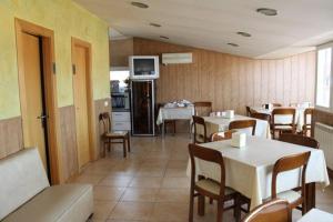 a dining room with tables and chairs and a television at Hostal Valle del Iregua in Albelda de Iregua