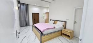 - une chambre avec un lit recouvert d'une couverture rose dans l'établissement Aberdeen SeaView Affordable Luxury Apartment by Richview, à Freetown