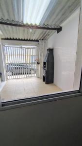 a view through a window of a room with a balcony at Casa na Guilhermina 500mt da praia in Praia Grande