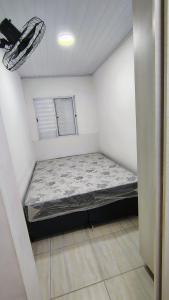 a small room with a bed in the corner at Casa na Guilhermina 500mt da praia in Praia Grande