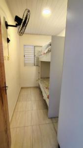 a room with a room with a bed and a light at Casa na Guilhermina 500mt da praia in Praia Grande +4 photos