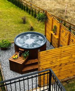 a hot tub in a yard next to a fence at ORAWSKA CHATA - domek z balią pod Babią Górą in Zubrzyca Górna