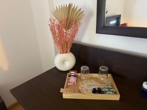 - une table avec un plateau de verres et un vase dans l'établissement Hotel Mina, à Craiova 5 autres photos