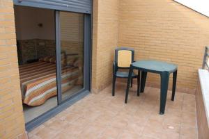 a patio with a table and a chair and a bed at Hostal Valle del Iregua in Albelda de Iregua
