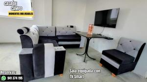 a living room with a couch and a table and a tv at Escápate con tu pareja sin salir de Lima in Cieneguilla
