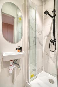 ein Badezimmer mit Waschbecken und Dusche in der Unterkunft Suite Anna In Paris Republique in Paris