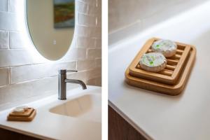 a bathroom with a sink and a mirror at Gastsuite het Duinroosje met hottub op het privé terras! in Den Burg