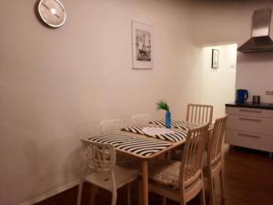 a dining room table with chairs and a clock on the wall at Stylish 2BR in Old Town Gem in Riga