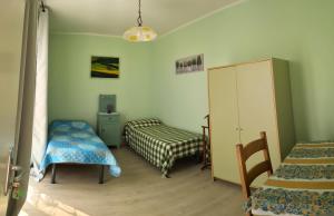 1 dormitorio con 2 camas, armario y mesa en Casetta Belvedere, en Valle San Nicolao
