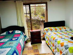 1 Schlafzimmer mit 2 Betten neben einem Fenster in der Unterkunft Cabaña Campestre Renacer in Paipa