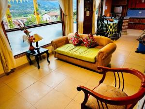ein Wohnzimmer mit Couch und großem Fenster in der Unterkunft Cabaña Campestre Renacer in Paipa