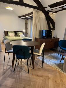a room with a table and chairs and a bed at Le Nid Bellifontain - Appartement Confort - Centre in Fontainebleau +8 photos