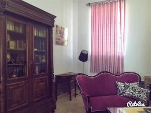 ein Wohnzimmer mit einem lila Sofa und einem Schrank in der Unterkunft Hotel Andalou in Montellano