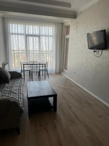 un salon avec une table et une télévision au mur dans l'établissement Sumqait Baxchasheher Center, à Soumgaït