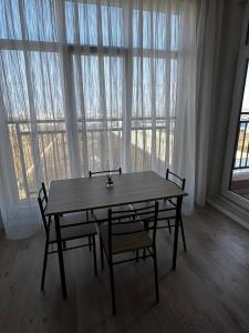une table et des chaises devant une grande fenêtre dans l'établissement Sumqait Baxchasheher Center, à Soumgaït