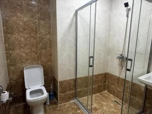 une salle de bain avec toilettes et douche en verre dans l'établissement Sumqait Baxchasheher Center, à Soumgaït 28 autres photos