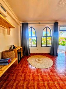 a living room with two windows and a rug at Marea Boutique Hotel in Jambiani +38 photos
