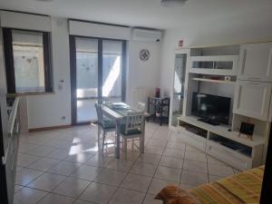 ein Wohnzimmer mit Tisch und Fernseher in der Unterkunft Papaya58 in San Benedetto del Tronto