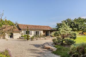 a house with a gravel driveway in front of it at Villa, piscine chauffée, aux portes de Lyon in Sainte-Euphémie