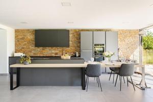 a kitchen with a large table and chairs at Villa, piscine chauffée, aux portes de Lyon in Sainte-Euphémie +11 photos