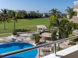 ein Balkon mit Swimmingpool und Golfplatz in der Unterkunft Golf Course View Apartment in Mazatlan in Los Cerritos