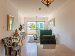 ein Wohnzimmer mit zwei Stühlen und einem Tisch in der Unterkunft Golf Course View Apartment in Mazatlan in Los Cerritos