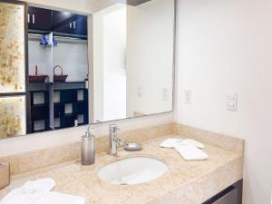 ein Badezimmer mit Waschbecken und großem Spiegel in der Unterkunft Golf Course View Apartment in Mazatlan in Los Cerritos + 32 Fotos