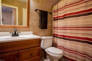 Un baño con inodoro, lavabo y cortina de ducha. en 4182 Thistle cir, en Virginia Beach
