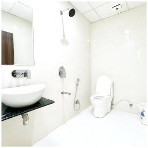 une salle de bain blanche avec un lavabo et des toilettes dans l'établissement Hotel RG Laxmi Palace Villas Near Vishwanath Temple # Parking- free Wi-fi Facilities # BEST HOTEL, à Varanasi