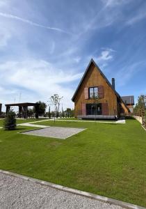 a large wooden house with a grassy yard at Villa Marina in Novoberdo