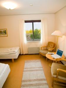 Zimmer mit einem Bett und einem Tisch mit einem Laptop in der Unterkunft Tofta Strandpensionat in Tofta