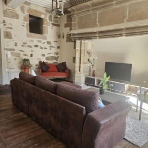 a living room with a couch and a television at Gite Maison Loyac in Tulle