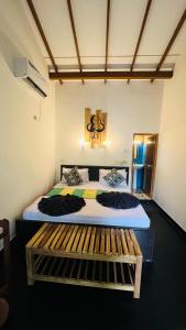 Un dormitorio con dos camas y un banco. en Sigiri Liya Rest, en Sigiriya 53 fotos más