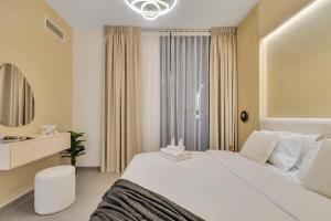 Postel nebo postele na pokoji v ubytování 1 Bedroom in Aljada City Center l Balcony & Pool - LemonHomes + 50 fotografií