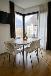 蒂拉诺Bernina Suites - vicino al Bernina Express的一张餐桌，几把椅子，还有一扇大窗户