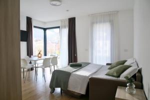a bedroom with a large bed and a dining room at Bernina Suites - 150 metres to Bernina Express in Tirano