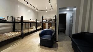 Sumaq Hostel Backpackers في بوينس آيرس: غرفة بها ثلاثة أسرة بطابقين وكرسي +21 صورة