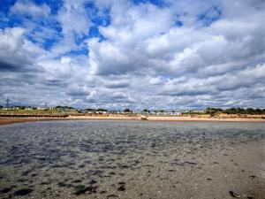 a beach with a cloudy sky and the water at Cabin 100 in Warsash