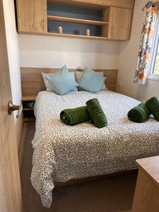 a bedroom with a bed with green pillows on it at Cabin 100 in Warsash