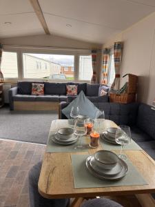 a living room with a table with plates and wine glasses at Cabin 100 in Warsash