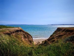 a beach with the ocean behind two large rocks at Cabin 100 in Warsash +11 photos
