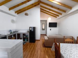 a kitchen and living room with a table and a couch at Cabañas Sol y Luna Lago Ranco in Lago Ranco