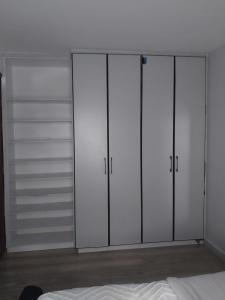 una camera da letto con armadi bianchi e un letto di Empiris Luxe Homes a Narok