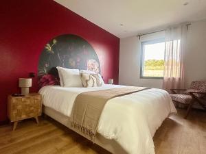 ein Schlafzimmer mit einem großen Bett mit einer roten Wand in der Unterkunft Escale Doullennaise - Appartement neuf avec terrasse in Doullens