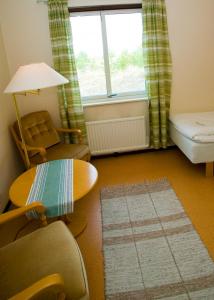 a living room with a table and a chair and a window at Tofta Strandpensionat in Tofta