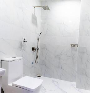 um banheiro branco com vaso sanitário e chuveiro em Ocean Sunset em Dhangethi