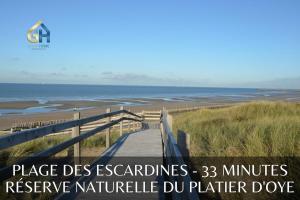 une promenade en bois menant à la plage avec les mots place des acadies minutes réserve dans l'établissement Le duplex de Belle Rade - proche centre et plage, à Dunkerque