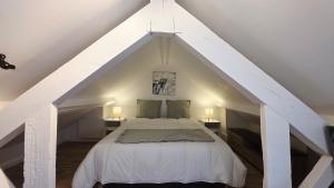 - une chambre mansardée avec un lit blanc dans l'établissement Le duplex de Belle Rade - proche centre et plage, à Dunkerque 35 autres photos