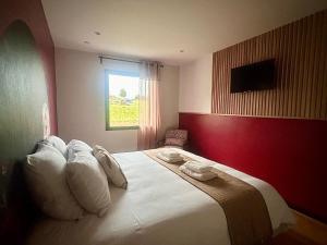 ein Schlafzimmer mit einem großen Bett und weißen Kissen in der Unterkunft Escale Doullennaise - Appartement neuf avec terrasse in Doullens