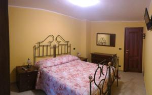 ペスココスタンツォにあるB&B Il Fratinoのベッドルーム1室(ピンクのベッドカバー、テーブル2台付)